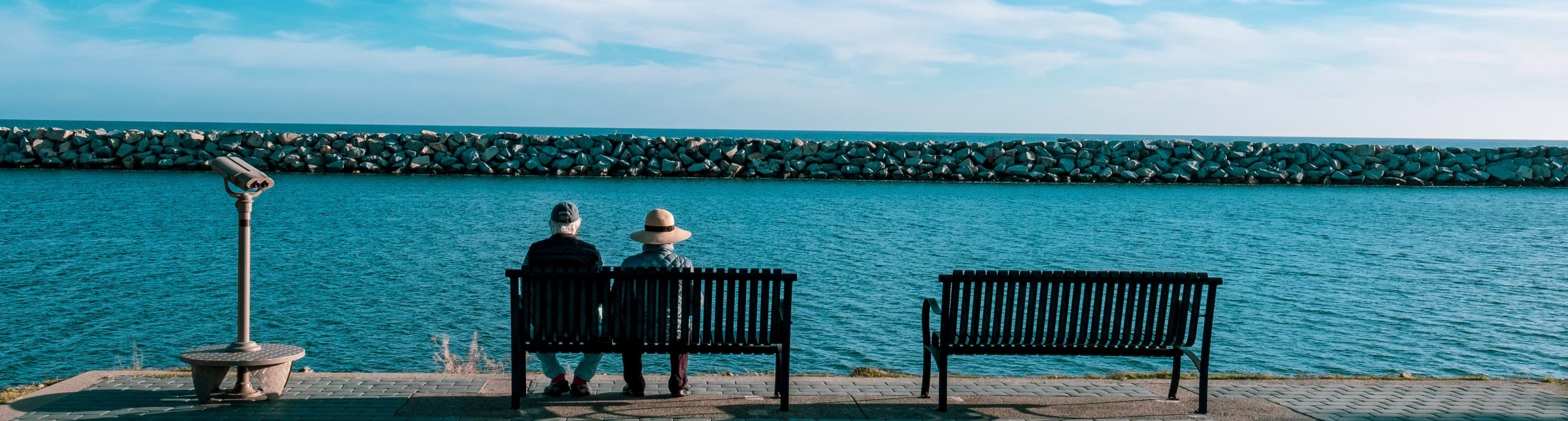 investments-header-elderlycouple-sitting-on-bench-at-the-beach AGED CARE ASSISTANCE
